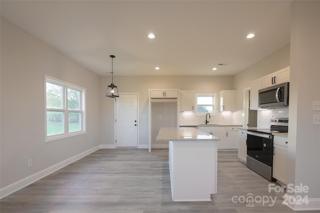 kitchen with white cabinets, stainless steel appliances, and a healthy amount of sunlight