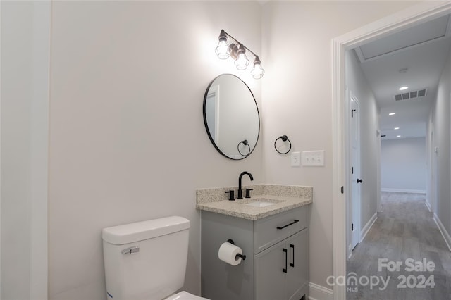 bathroom featuring hardwood / wood-style flooring, vanity, and toilet