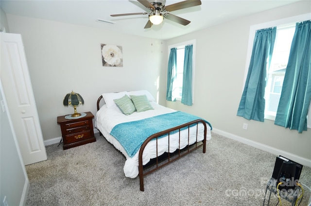 bedroom with multiple windows, light colored carpet, and ceiling fan