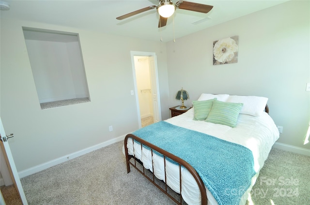 carpeted bedroom featuring ceiling fan and ensuite bath