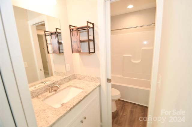 full bathroom with vanity, toilet, wood-type flooring, and tub / shower combination