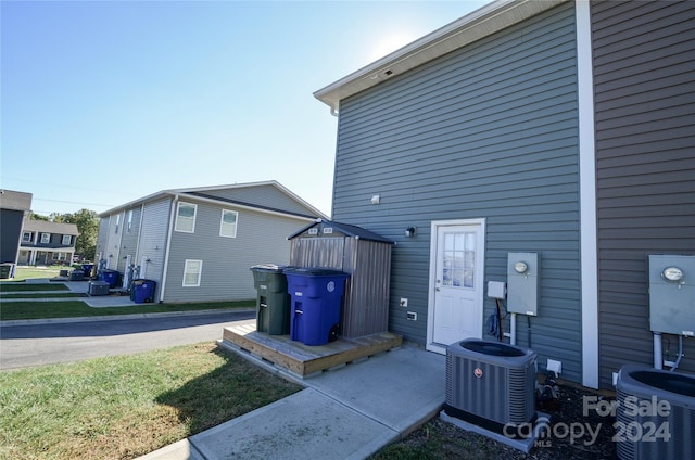 view of property exterior with a yard and central AC unit