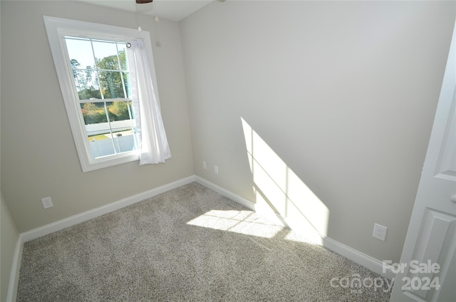 carpeted spare room with ceiling fan