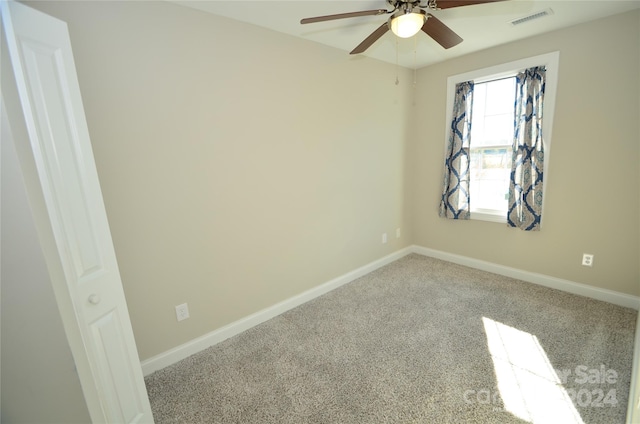 carpeted spare room with ceiling fan