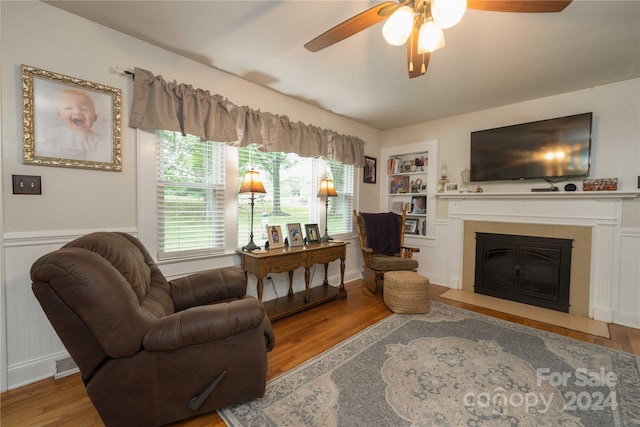 living room featuring a fireplace, wood-type flooring, and ceiling fan