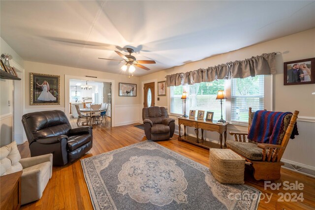 416 W Main St, Mooresboro, NC 28114 - living area featuring ceiling fan, a chandelier, a wainscoted wall, and wood finished floors