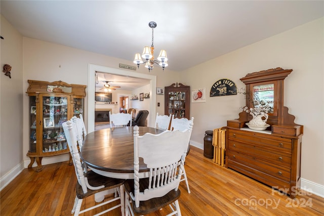 416 W Main St, Mooresboro, NC 28114 - dining room with a chandelier, light wood-style flooring, a glass covered fireplace, and baseboards