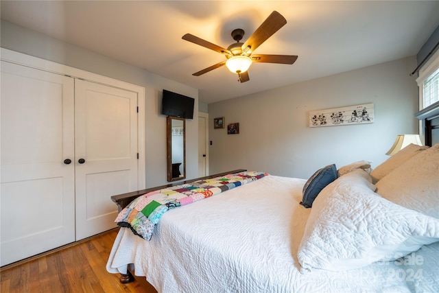 bedroom with a closet, hardwood / wood-style flooring, and ceiling fan