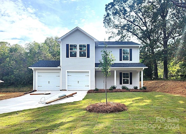 view of front of house featuring a porch, a front lawn, and a garage