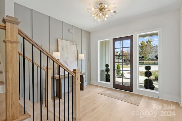 entryway with light wood-type flooring and a chandelier