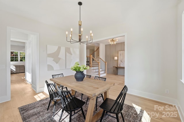 571 Lyttleton Dr, Charlotte, NC 28211 - dining room featuring light wood-style floors, a notable chandelier, baseboards, and stairway