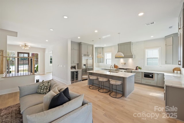 571 Lyttleton Dr, Charlotte, NC 28211 - kitchen featuring open floor plan, gray cabinets, a sink, appliances with stainless steel finishes, and custom exhaust hood