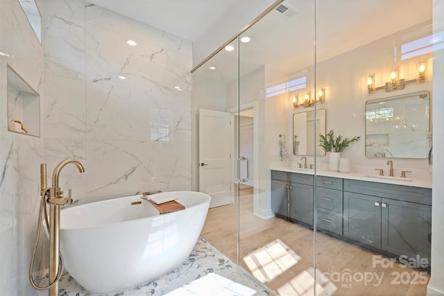 571 Lyttleton Dr, Charlotte, NC 28211 - full bath featuring a freestanding tub, a sink, wood finished floors, visible vents, and double vanity