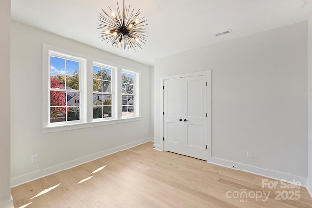 571 Lyttleton Dr, Charlotte, NC 28211 - unfurnished bedroom with baseboards, light wood-style flooring, and an inviting chandelier