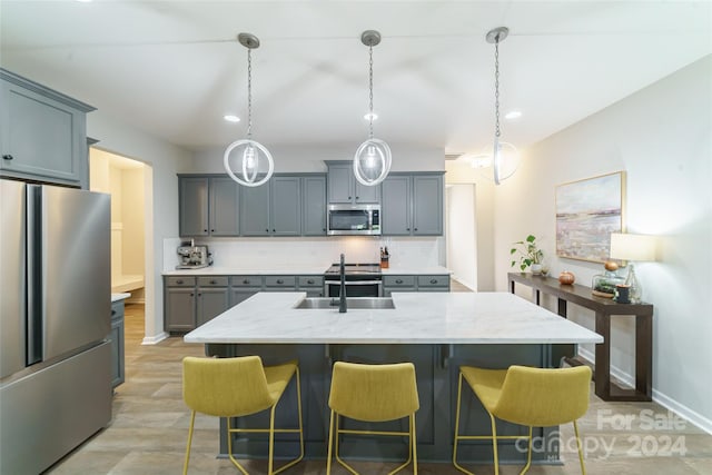 kitchen with a center island with sink, decorative backsplash, hanging light fixtures, and stainless steel appliances