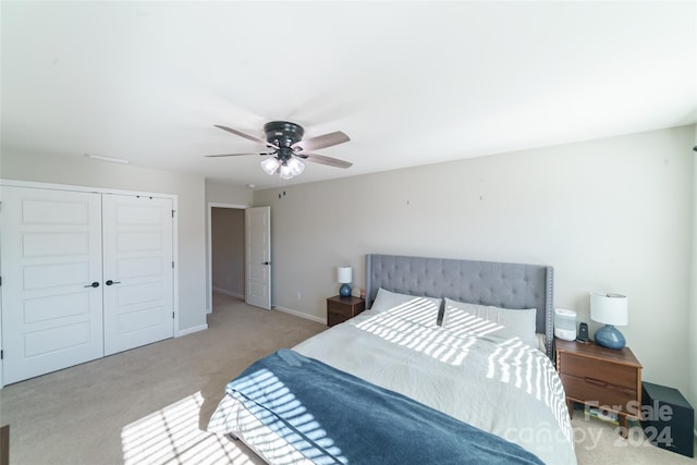 bedroom featuring a closet, ceiling fan, and light colored carpet