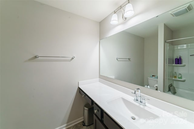 bathroom with toilet, vanity, and a shower