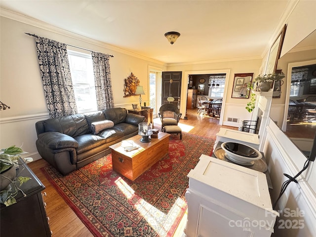 living room with wood-type flooring and ornamental molding