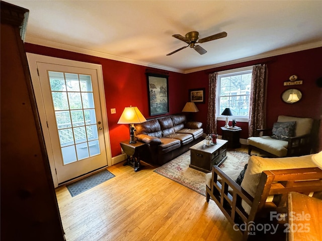 living room with ornamental molding, ceiling fan, and light hardwood / wood-style flooring