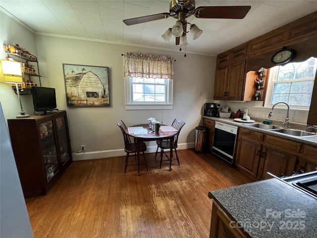 kitchen featuring dark wood-type flooring, sink, tasteful backsplash, ornamental molding, and black dishwasher