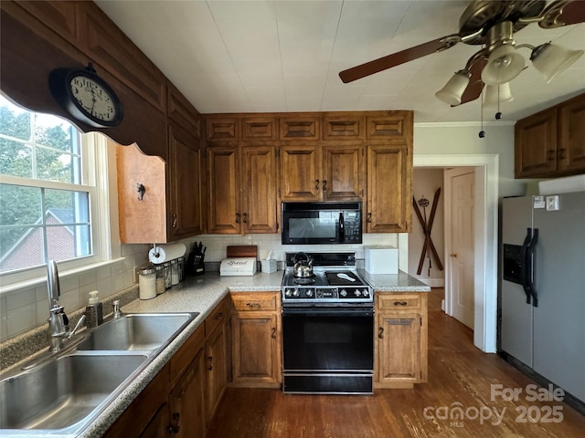 kitchen featuring sink, dark hardwood / wood-style flooring, ceiling fan, decorative backsplash, and black appliances