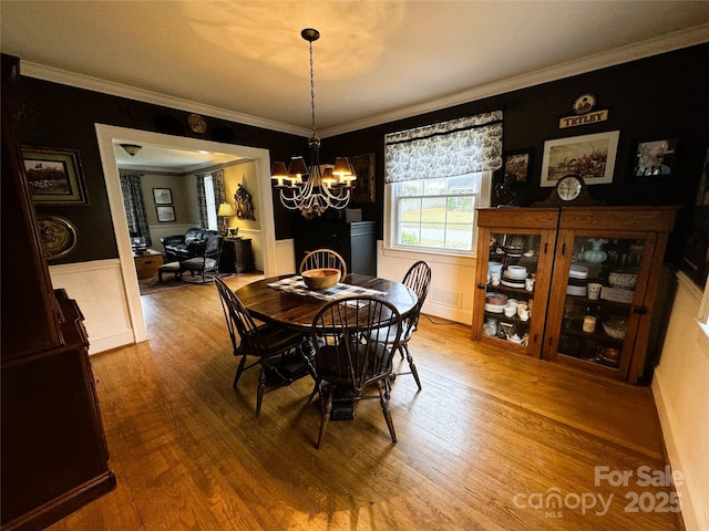 dining room featuring crown molding, a chandelier, and hardwood / wood-style floors