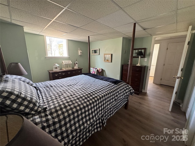 bedroom with hardwood / wood-style flooring and a paneled ceiling