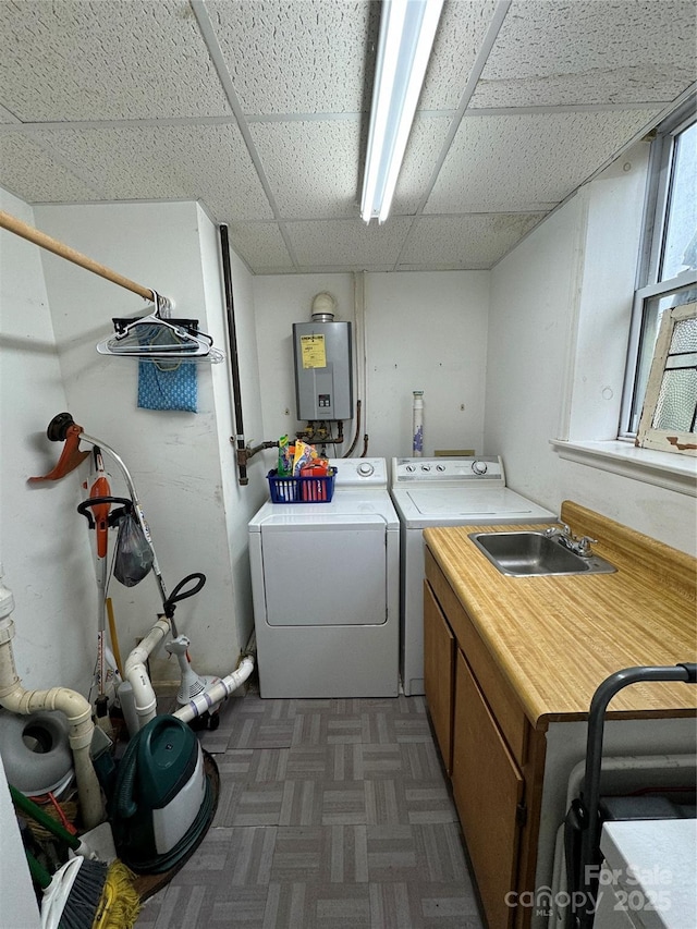 laundry room with dark parquet floors, sink, cabinets, tankless water heater, and washer and clothes dryer