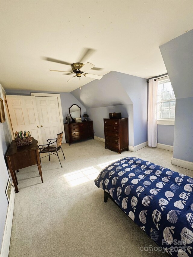 bedroom with ceiling fan, vaulted ceiling, a closet, and carpet