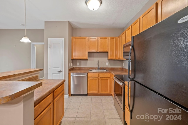 kitchen with hanging light fixtures, appliances with stainless steel finishes, a textured ceiling, light tile patterned flooring, and sink