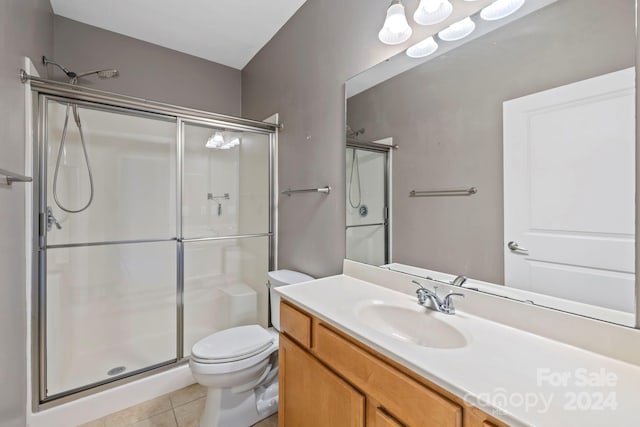 bathroom featuring vanity, tile patterned floors, toilet, and walk in shower