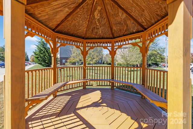 wooden deck featuring a gazebo and a lawn