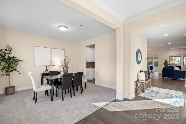 dining room featuring crown molding and dark colored carpet