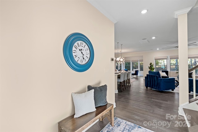 interior space with ceiling fan with notable chandelier, dark hardwood / wood-style floors, and crown molding