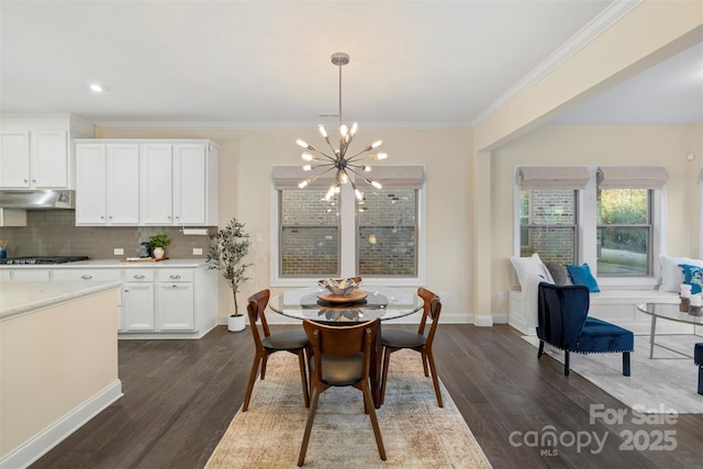 dining area with a chandelier, ornamental molding, and dark hardwood / wood-style flooring