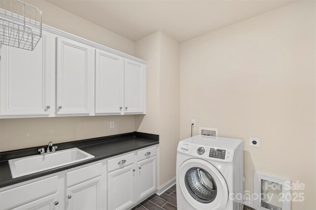 laundry area featuring sink, washer / dryer, and cabinets