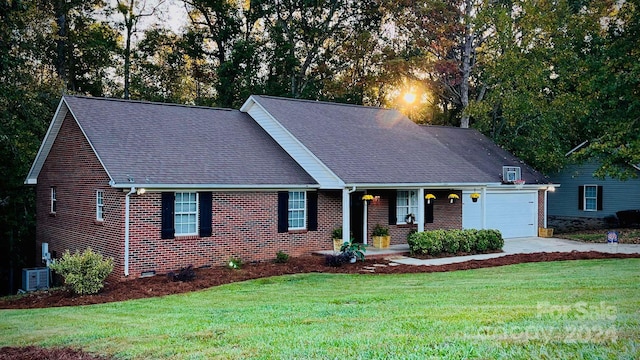 view of front of house with a garage, cooling unit, and a front lawn