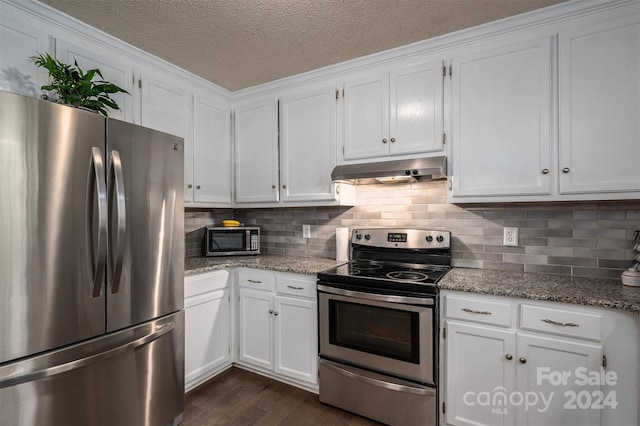 kitchen featuring light stone counters, stainless steel appliances, a textured ceiling, white cabinets, and dark wood-type flooring