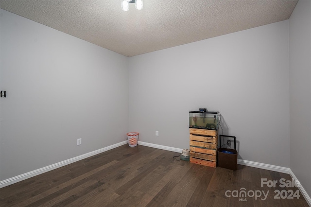 empty room featuring dark wood-type flooring and a textured ceiling