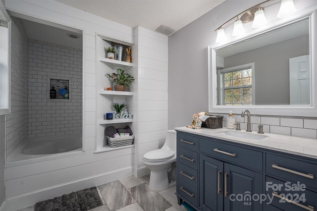 full bathroom featuring vanity, a textured ceiling, toilet, and tiled shower / bath