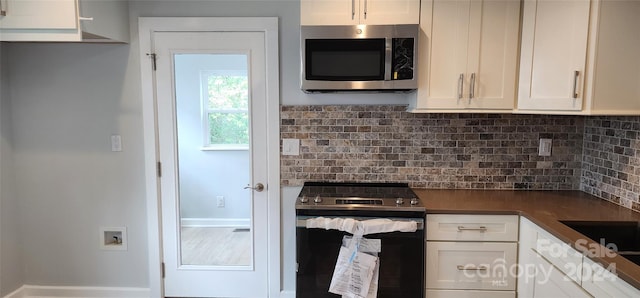 kitchen featuring decorative backsplash, white cabinetry, and stainless steel appliances