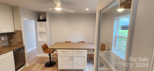 kitchen featuring decorative backsplash, white cabinets, black dishwasher, ceiling fan, and light hardwood / wood-style flooring