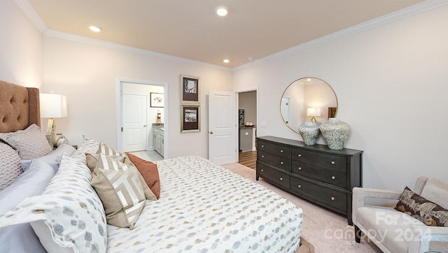 bedroom featuring ornamental molding, ensuite bathroom, and light colored carpet