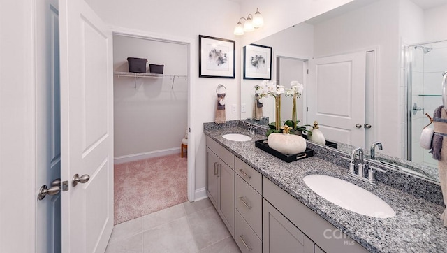 bathroom with a shower with door, vanity, an inviting chandelier, and tile patterned floors