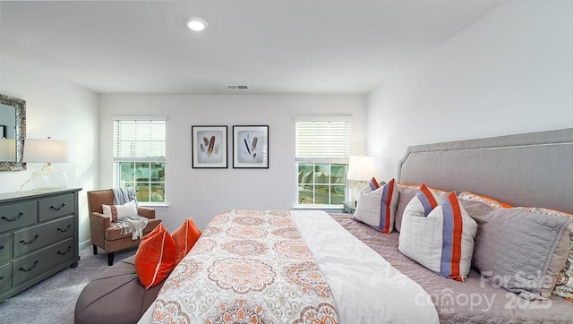 bedroom with light colored carpet and multiple windows