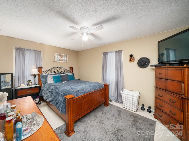 carpeted bedroom featuring a textured ceiling and ceiling fan