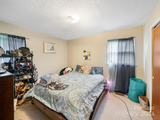 carpeted bedroom featuring a textured ceiling