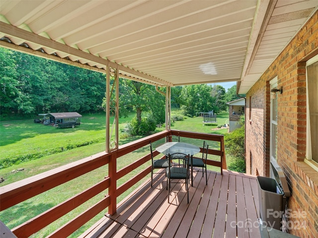 wooden terrace featuring a yard