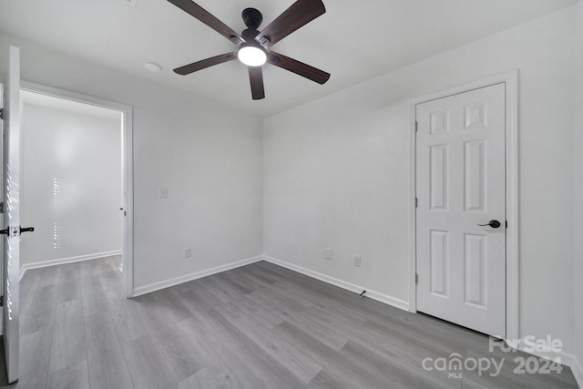 spare room with ceiling fan and light wood-type flooring