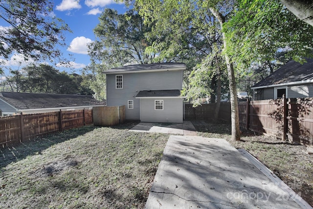 rear view of property with a yard and a patio